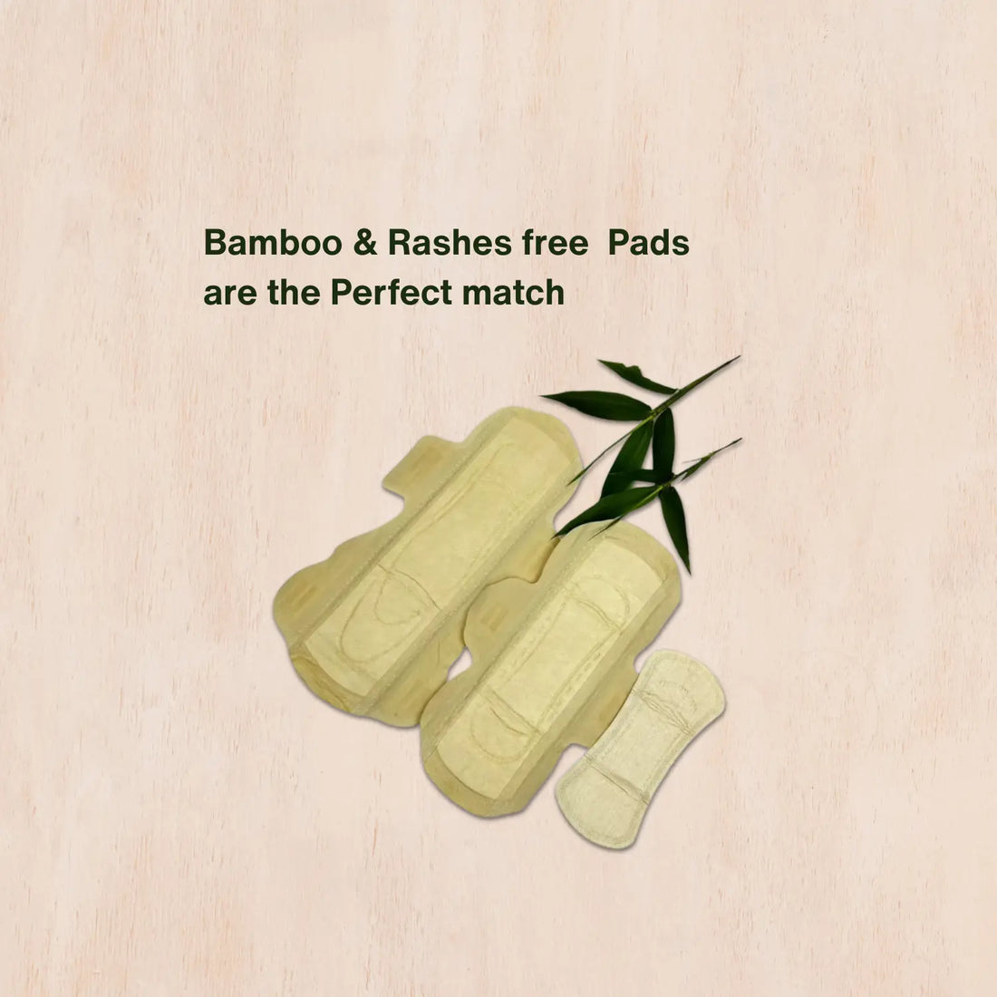 Three light‑beige bamboo menstrual pads in small, regular, and night sizes, laid out on a wooden surface with a small bamboo branch—accompanied by text: ‘Bamboo & Rashes free Pads are the Perfect match.